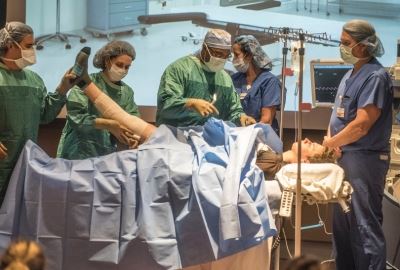 people performing surgery in front of students